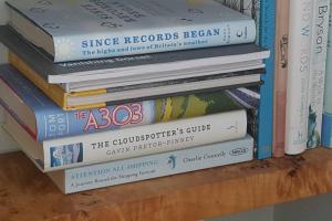 a stack of books sitting on a shelf at Bentley Rise in Lyme Regis