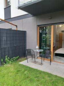 a patio with two chairs and a table in a yard at Na Grobli 20 Apartament z ogródkiem in Wrocław