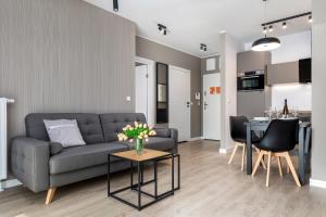 een woonkamer met een bank en een tafel bij Modern City Center Apartments by Renters in Poznań