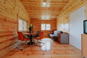um quarto com paredes de madeira e uma mesa e cadeiras em Wioska Rybacka Wilga em Wilga