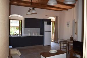 a kitchen with black cabinets and a white refrigerator at Taygetus apartments in Xirokámbion