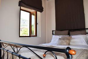 um quarto com uma cama, uma janela e um espelho em Taygetus apartments em Xirokámbion
