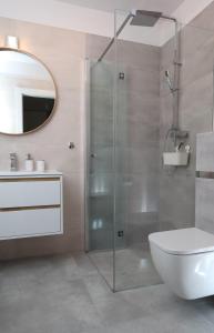 a bathroom with a shower with a toilet and a sink at Apartament Szmaragdowy Platan in Kołobrzeg