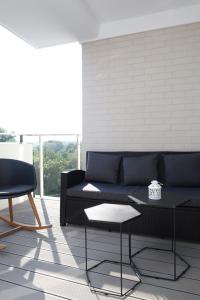 a living room with a black couch and a table at Apartament Szmaragdowy Platan in Kołobrzeg
