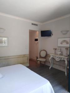 a bedroom with a bed and a table and a tv at La Cabana Cinque Terre Monterosso in Monterosso al Mare