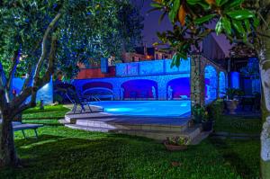una piscina en un patio por la noche en Domus Parthenope, en Boscotrecase