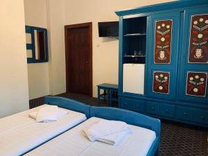 a room with two beds and a blue cabinet at Székely Fogadó - Hanul Secuiesc in Băile Tuşnad