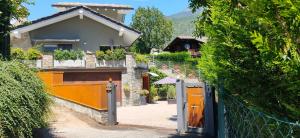 una casa con una puerta naranja y una valla en Maison Beauregard, en Aosta