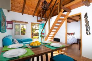 un comedor con una mesa de madera y una escalera en Karma House, en Casares