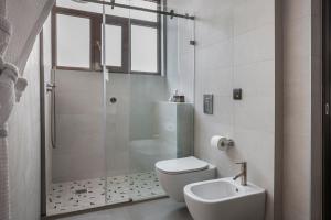 uma casa de banho com um chuveiro, um WC e um lavatório. em Royalty Hotel Athens em Atenas