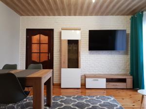 a living room with a table and a tv on a wall at ZIELONE ZACISZE Joanna Kulpa in Janów Lubelski