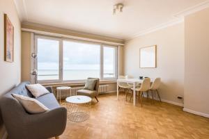 uma sala de estar com mesa e cadeiras em Seaview apartment for 2 in Ostend em Oostende