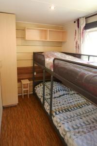 two bunk beds in a room with a window at Camping la Palmyre in Les Mathes