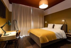 een hotelkamer met een bed en een bureau en een bed sidx sidx sidx sidx bij Hotel1875 in Antwerpen