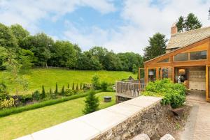 an exterior view of a house with a garden at Hollyhock House in Stonesfield