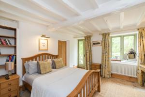 a bedroom with a bed and a window at Hollyhock House in Stonesfield +66 photos