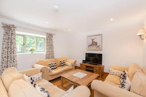 a living room with couches and a flat screen tv at Hollyhock House in Stonesfield