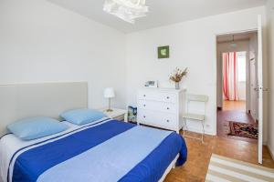 1 dormitorio con 1 cama azul y vestidor blanco en Le Saint É, en Dinard