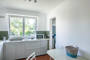 cocina blanca con fregadero y ventana en Le Saint É, en Dinard