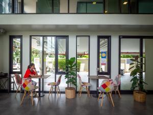 a woman sitting at a table in a restaurant at Casaluxe Hotel and Resident in Bangkok