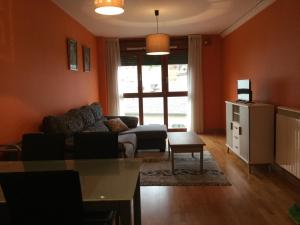 Apartamento Rio Barayo في لواركا: غرفة معيشة مع أريكة وطاولة