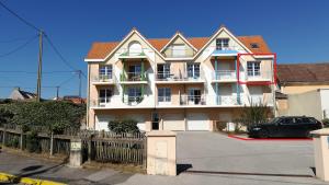 ein großes Haus mit einem davor geparkt in der Unterkunft Appartement l'Estivalière face à la mer in Wimereux