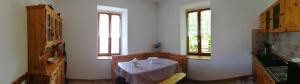 eine Küche mit einem Tisch und 2 Fenstern in der Unterkunft B&b Zita in Levico Terme