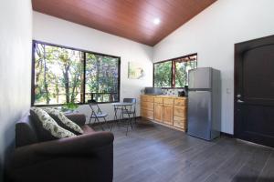 Il dispose d'une cuisine et d'un salon avec un réfrigérateur et des fenêtres. dans l'établissement Green Habitat, à Monteverde Costa Rica