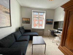 a living room with a couch and a tv at PSG 23 - Short Stay Apartments by Living Suites in Copenhagen