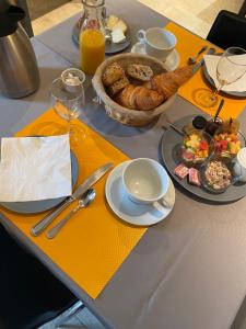 a table with plates of food and a basket of bread at Maison d'hôtes & Gîtes Domaine de la Garaye in Dinan