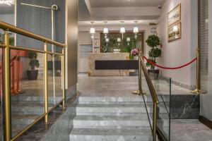 a lobby with a staircase and a reception desk at Royalty Hotel Athens in Athens