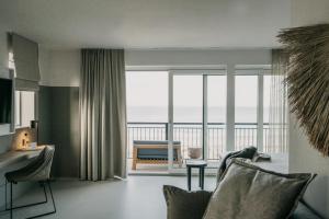 a living room with a view of the ocean at Strandhotel in Cadzand-Bad