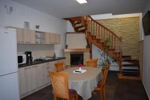 a kitchen and dining room with a table and a staircase at Casa Edelweiss in Sinaia