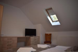 a bedroom with a bed and a desk with a television at Casa Edelweiss in Sinaia