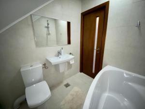 a bathroom with a white toilet and a sink at Casa Edelweiss in Sinaia +31 photos