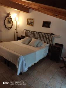 - une chambre avec un grand lit dans l'établissement Agriturismo Ribuntà, à Caiolo