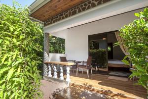 een patio met een houten tafel en stoelen bij Tannette Villa in La Digue