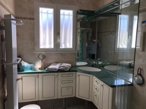 a bathroom with two sinks and a person taking a picture at St Georges de Didonne, Maison bien équipée au calme in Saint-Georges-de-Didonne