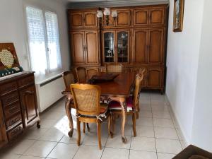 een eetkamer met een houten tafel en stoelen bij St Georges de Didonne, Maison bien équipée au calme in Saint-Georges-de-Didonne