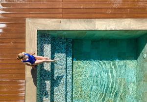 una mujer está nadando en una piscina en Hotel Resort & Spa Miramonti, en Rota d'Imagna