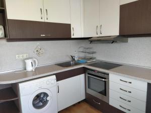 a kitchen with a sink and a washing machine at Sunny Sands Studios in Burgas