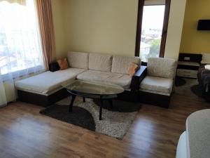 a living room with a couch and a coffee table at Sunny Sands Studios in Burgas