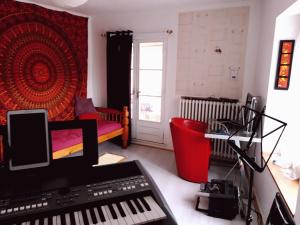 Habitación con teclado y dormitorio con cama en Résidence Tivoli, en Limoux