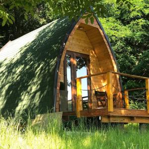 una piccola casa igloo in legno immersa nell'erba di Glamping Jezero a Čačak