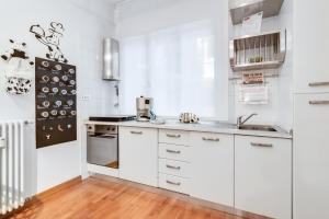 una cocina con armarios blancos y electrodomésticos blancos en Ospedale & Galleria Ognissanti Apartment, en Padua