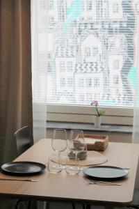 a table with two wine glasses and a window at Gallen-Kallelankatu 5 in Pori