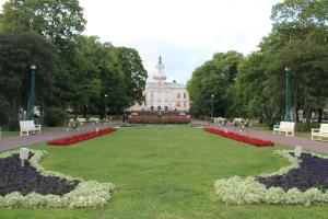 a large park with white benches and flowers in front of a building at Gallen-Kallelankatu 5 in Pori