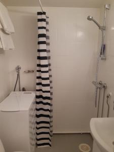 a bathroom with a shower and a black and white shower curtain at Gallen-Kallelankatu 5 in Pori