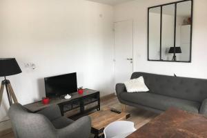 a living room with a couch and a tv at Gîte de chenieux in Saint-Victor-sur-Loire