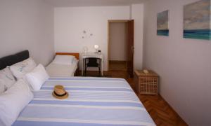 a bedroom with a bed with a hat on it at Rooms & Apartments Dolac in Hvar